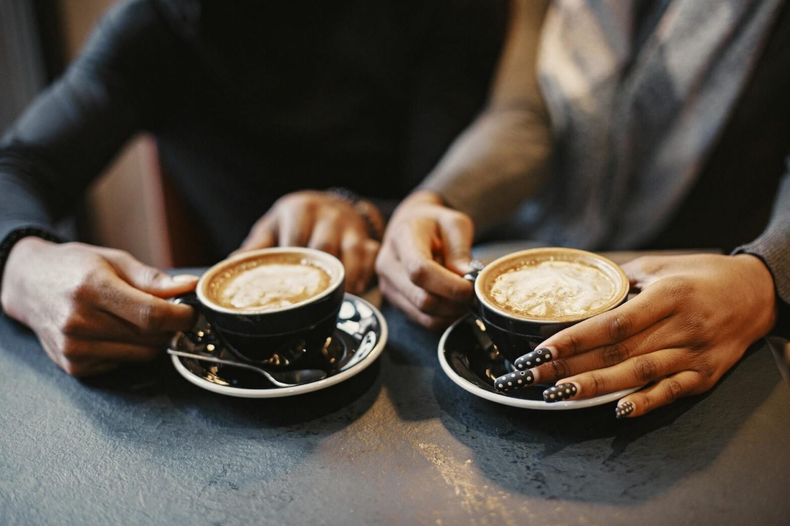 couple hand holding coffee cups