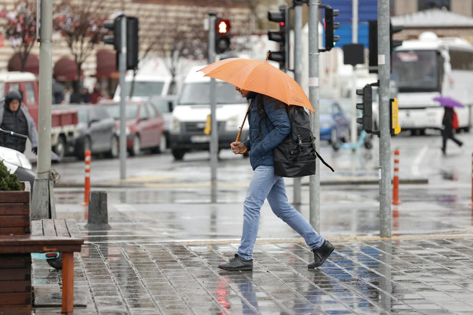 man with orange umbrella walking in rainy istanbul